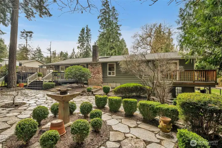 Backyard oasis, with garden beds, flagstone patios, dual decks & magical lighting at night.