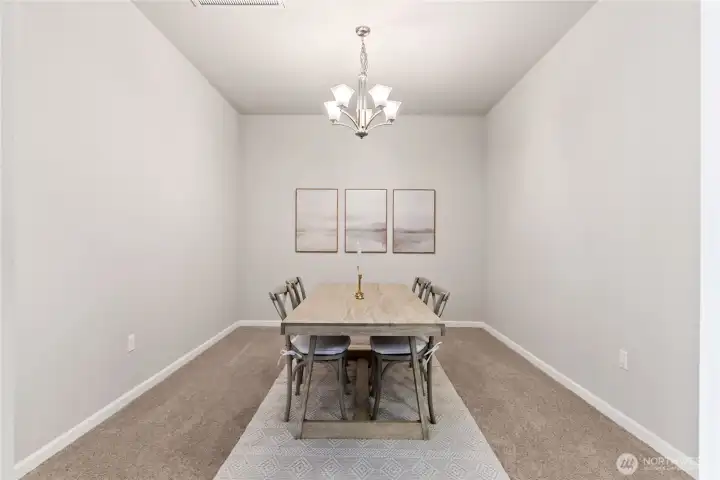 Elegant formal dining room with soaring ceilings, modern chandelier, and neutral tones that complement any décor. This spacious area is perfect for hosting gatherings, dinner parties, or enjoying everyday meals in a bright and refined setting.