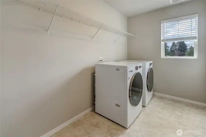 Oversized laundry room with wire shelving and washer and dryer included.