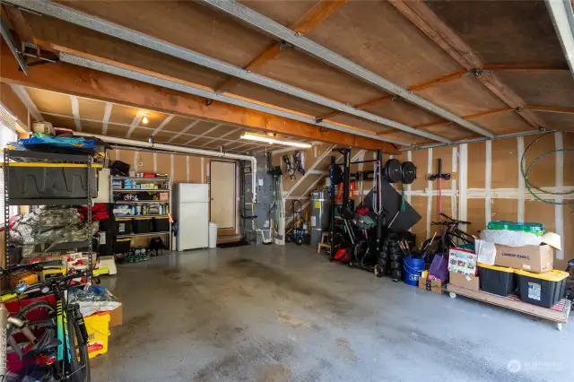 Garage is spacious enough for cars and additional storage.  Water heater and new furnace shown here. Fridge/freezer is an included appliance.