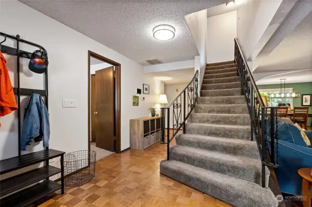 Upon entering the home, you can see downstairs bedroom to the left, front staircase, hall leading to kitchen, and living room and dining room to the right.