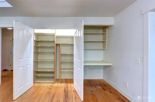Lighted pantry behind wide double doors.   Built-in workstation for cookbooks or laptop.