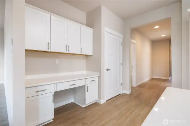 This home has a built in desk with upper cabinets and a pantry.