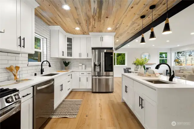 Kitchen island with quartz waterfall counters, stainless appliance package and subway tile backsplash