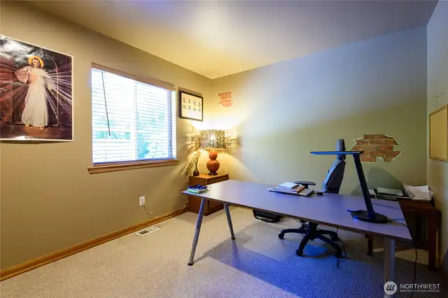 Bedroom #2 used as a home office.  Rich wood trim and custom, matching plantation blinds throughout the home.