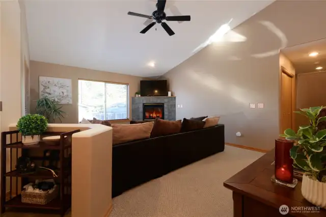 The living room features vaulted ceilings that enhance its spacious and airy feel. A cozy gas fireplace serves as a cozy focal point, providing warmth and ambiance with the flick of a switch.