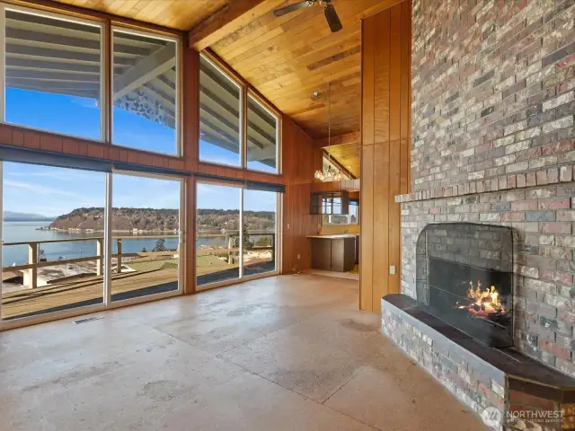 Floor to ceiling windows and fireplace highlight the greatroom's volume