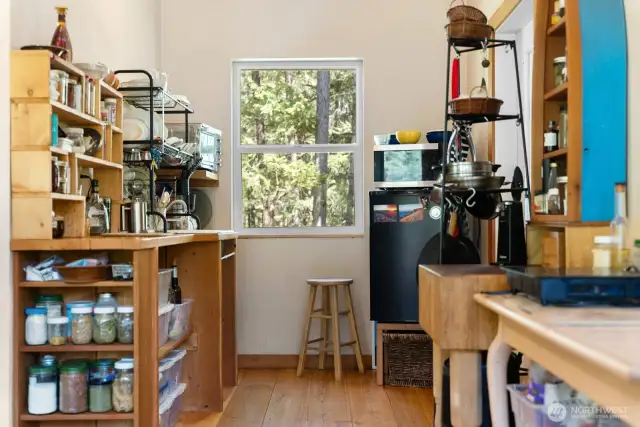 Compact kitchen done right! Hookup for an oven/range is behind the butcher block table on the right, and a regular sized fridge would actually fit between the door and the window!