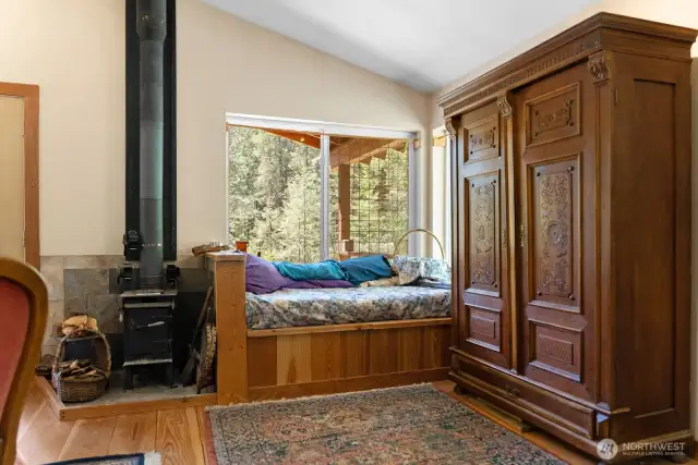 The corner daybed is designed to hold firewood that can be loaded from outside, or use it for storage of other items. The wood-stove, though small, is plenty sufficient to keep this well-insulated cabin warm through the winter.