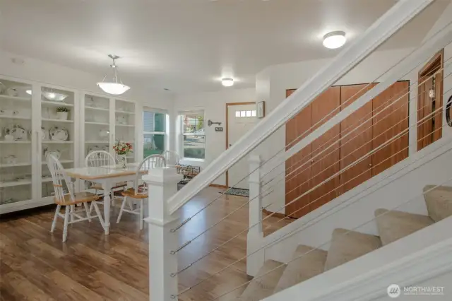 The inviting entryway offers a spacious coat closet and a convenient half bathroom nearby. The dining area sits just off the kitchen, making it perfect for both casual meals and entertaining. Straight ahead, the beautiful banister frames the stairway leading to the second floor, where you'll find the home's bedrooms, full bathrooms, and a large bonus area. The detached china cabinets in the dining area are not included in the sale of the home.