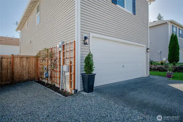 The property includes a gravel area for extra parking and a side gate for easy backyard access—plus, enjoy the charm of decorative climbing plants along the side yard!