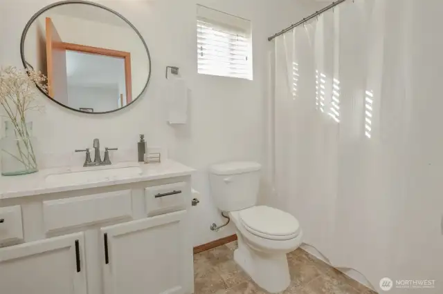 This full bathroom on the second floor is conveniently located near both bedrooms and just off the bonus area. Light and bright, it showcases a stylish vanity topped with a round mirror for a modern touch.