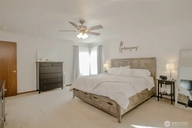 The generously sized primary bedroom is filled with natural light from corner windows. It also boasts a huge walk-in closet and a full en suite bathroom for your comfort and convenience.