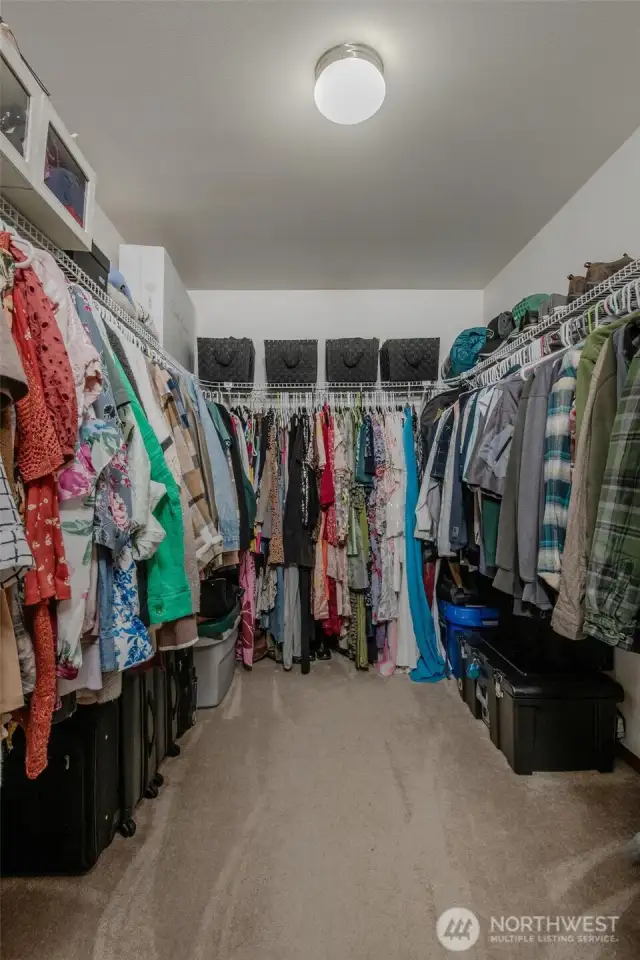 The oversized walk-in closet in the primary bedroom offers ample storage with plenty of hanging space and a full-length shelf above—perfect for keeping everything organized and within reach.