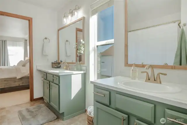 Just off the primary bedroom, this en suite bathroom offers two vanities, a full shower and tub, and plenty of bright lighting. Contemporary finishes give the space a fresh, modern look while maintaining everyday comfort and convenience.