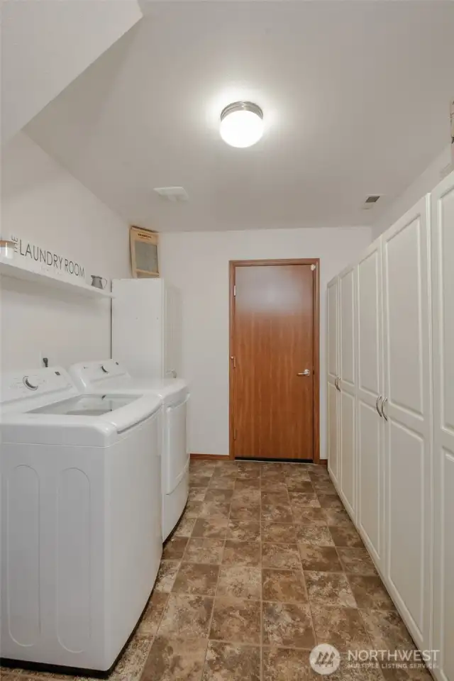 The spacious laundry room offers convenient access from both the garage and the main living area. Please note: washer, dryer, and detached storage cabinets/wardrobes are not included in the sale.