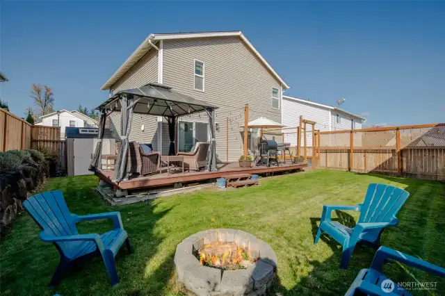 Step into the backyard from the kitchen through a sliding glass door that opens to a spacious deck with a cozy gazebo seating area. Enjoy entertaining around the fire pit, tending to raised garden beds, and storing tools with ease in the large shed—everything you need for outdoor living! The gazebo stays with the home!