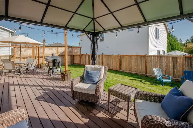 The gazebo on the deck offers a cozy, shaded spot to unwind while taking in views of the spacious, green lawn—an ideal setting for relaxing or entertaining outdoors.