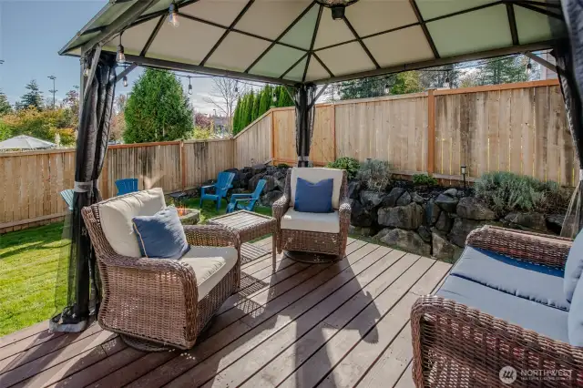 The gazebo on the deck provides a comfortable, shaded seating area just steps from the fire pit—perfect for gathering with friends and enjoying the backyard ambiance.