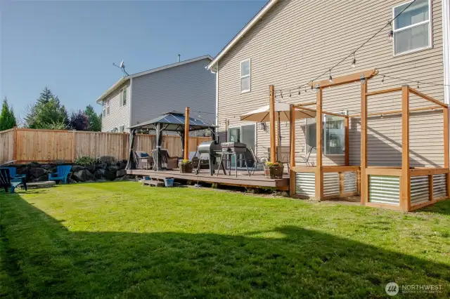 The spacious deck sits right beside beautifully crafted raised garden beds—perfect for enjoying your morning coffee while overlooking your own garden oasis.