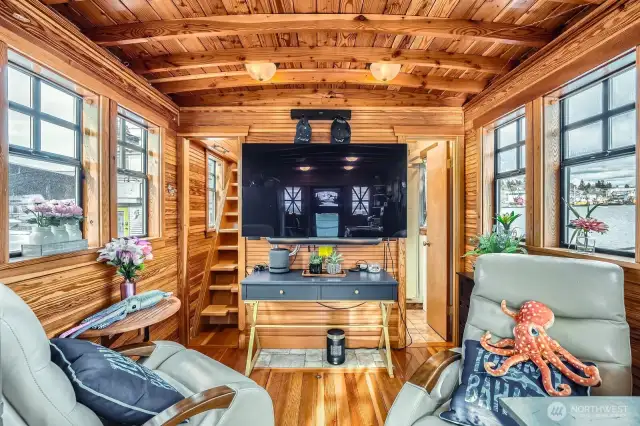 Walls of windows with lake and canal views wvwrywhere.  Viwe from the kitchen into the living room and to the right is the 3/4 bath. To the left you will LOVE the Pantry/Storage room, then up the stairs leads to the buil-in queen sized bedroom and lots of built-in storage space.