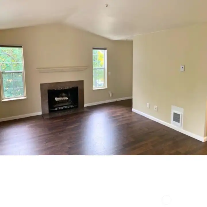 Vaulted living room with a slate wood burning fire place and a slider to the deck.