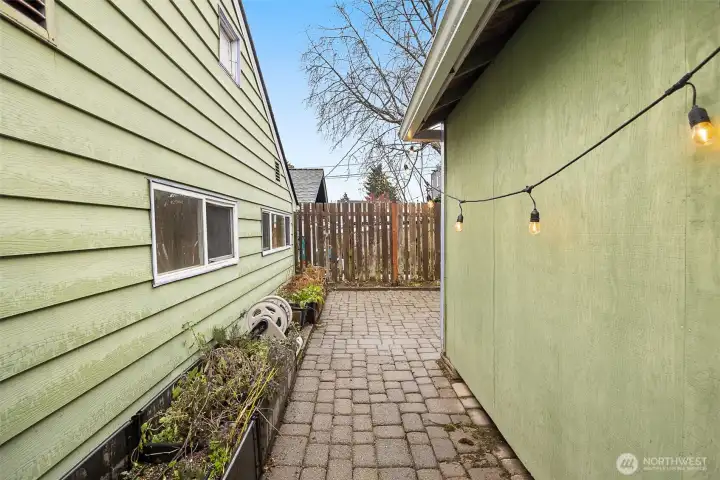 Walk way to the fenced in patio between the home (left) and garage (right)
