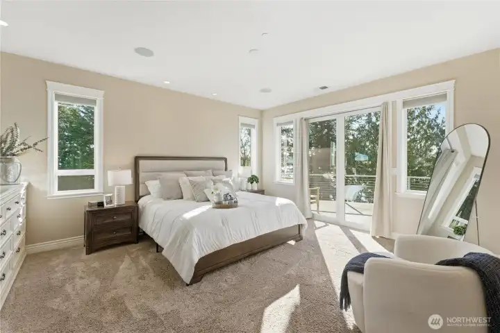 A serene primary bedroom with walk-out deck access showcases never-ending views and spectacular sunsets. The suite continues with a full bathroom, oversized laundry room, generous walk-in closet, and an office