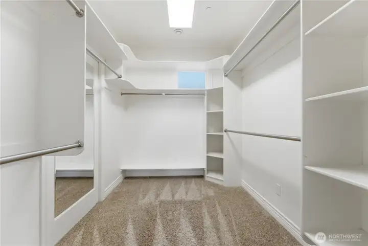 A large, well-appointed walk-in closet anchors the primary suite, offering generous storage and thoughtful organization