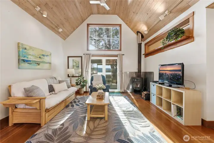 Cottage #1 features vaulted ceilings, a separate main bedroom, and an upstairs loft with a twin bedroom. The full bathroom sits just off the bathroom.  The main living overlooks the calm bay beyond the outdoor kitchen and deck