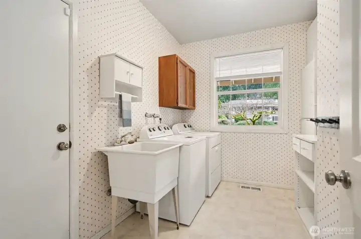 Laundry room off the garage with plenty of storage and sink