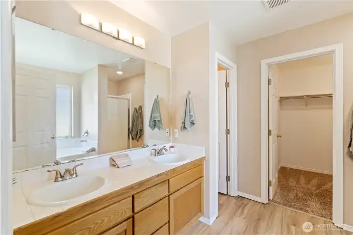 Primary bathroom has double sinks, separate room for toilet, walk-in closet, separate shower and soaking tub.