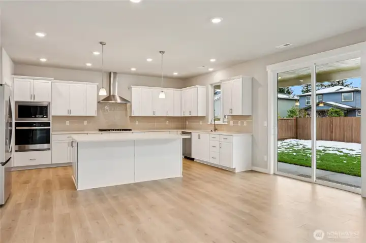 Kitchen opens out to landscaped and fenced back yard. Outdoor sprinkler systems front and back included!