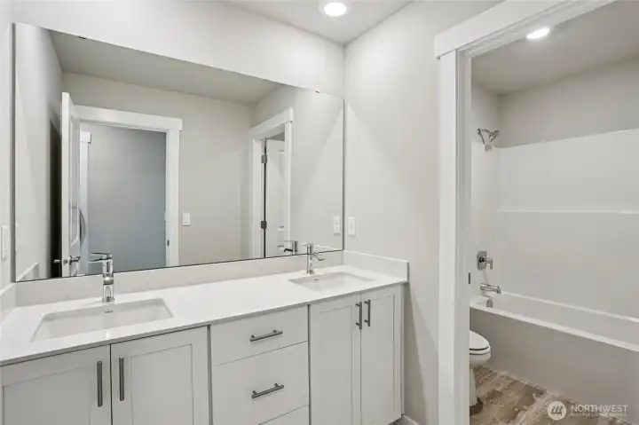 Guest bathroom with tub and quartz counters