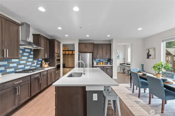 Stainless steel appliances: gas cook top, fridge, dishwasher, microwave, and wall oven.