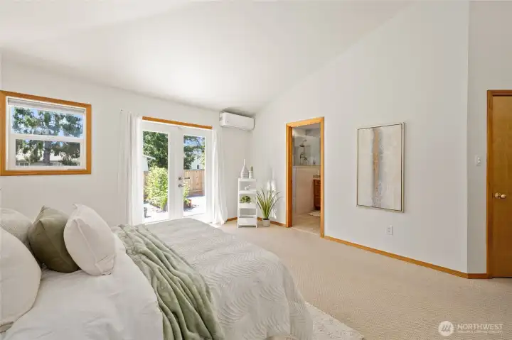 Spacious primary suite with French doors opening directly to the backyard patio.