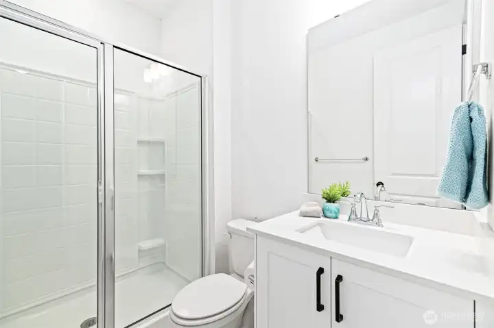 3/4 bathroom with large shower and vanity on main floor.