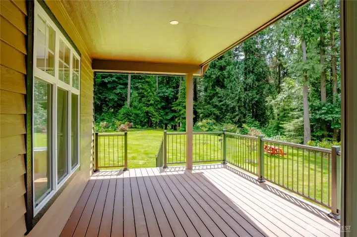 Covered back porch overlooking landscaped backyard