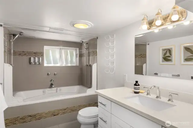 Full bath complete with quartz countertops and a jetted tub.