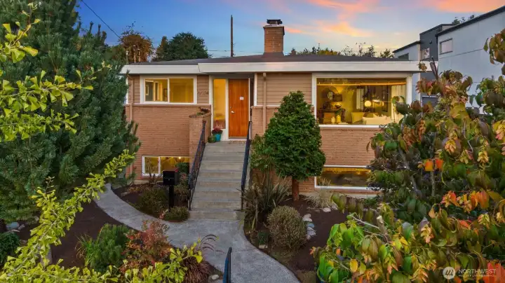 Sun-filled Seaview Mid-Century—gleaming hardwoods, iconic fireplace, and walls of windows blend timeless design with modern updates for effortless West Seattle living.