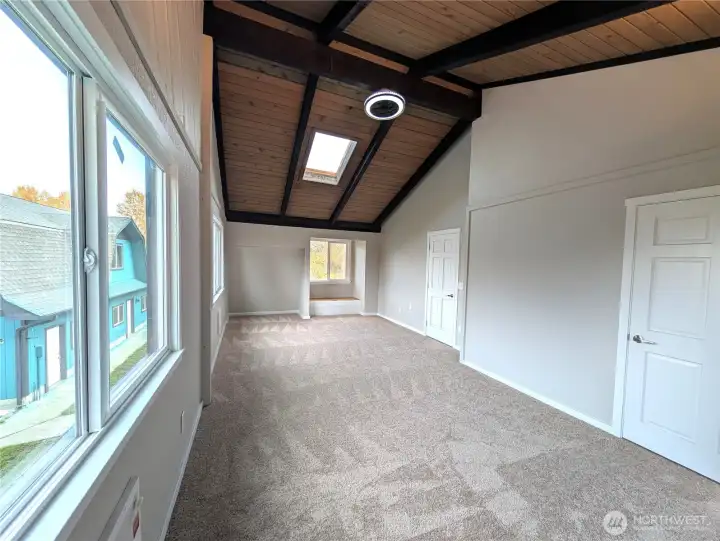 Opposite view of the 2nd bedroom.  Vaulted & open beam w/ceiling fan & bay window w/storage.