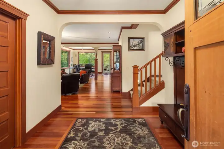 Welcoming foyer with rich hardwood floors and detailed millwork, creating a warm transition into the main living spaces.