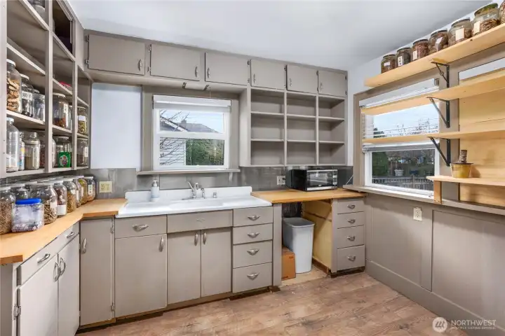 Enjoy abundant natural light and pleasant views from the kitchen’s vinyl windows, complemented by added shelving along the west wall.