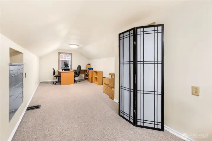 Versatile upper-level space ideal as an office or third bedroom, complete with newer carpet, updated lighting, vinyl windows, and A/C to keep the room cool on warm summer days.