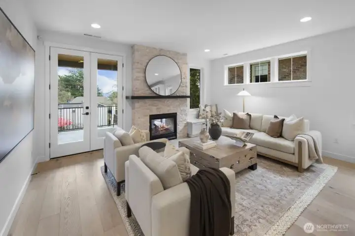 The great room centers around a fireplace and opens directly to covered outdoor living, blending comfort, light, and year-round livability.