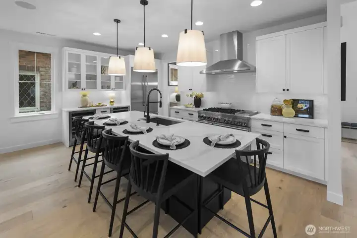 The kitchen pairs crisp cabinetry, professional-grade stainless appliances, and a large island with seating, delivering style and function at the heart of the home.