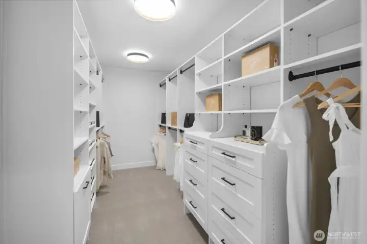 Custom closet design brings everyday luxury to the primary suite, with built-in drawers, open shelving, and thoughtfully organized storage throughout.