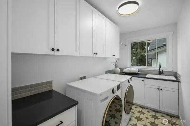 Spacious laundry room with abundant cabinetry, folding space, and a window that brings light into even the most practical corner of the home.