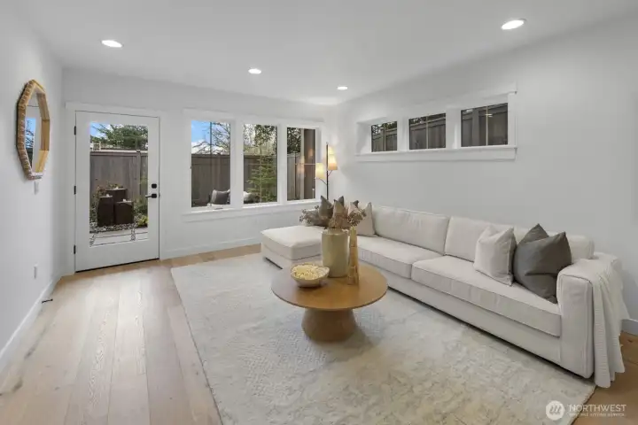 The lower-level living area offers a bright, welcoming retreat with direct access outside, creating flexible space for relaxing, hosting, or extended stays.