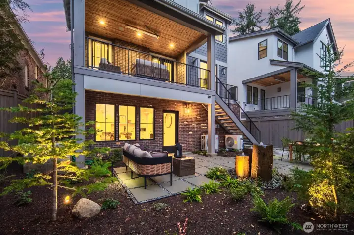 The rear outdoor spaces are designed to live like a private retreat, with layered patios, covered seating, and beautifully integrated landscaping.